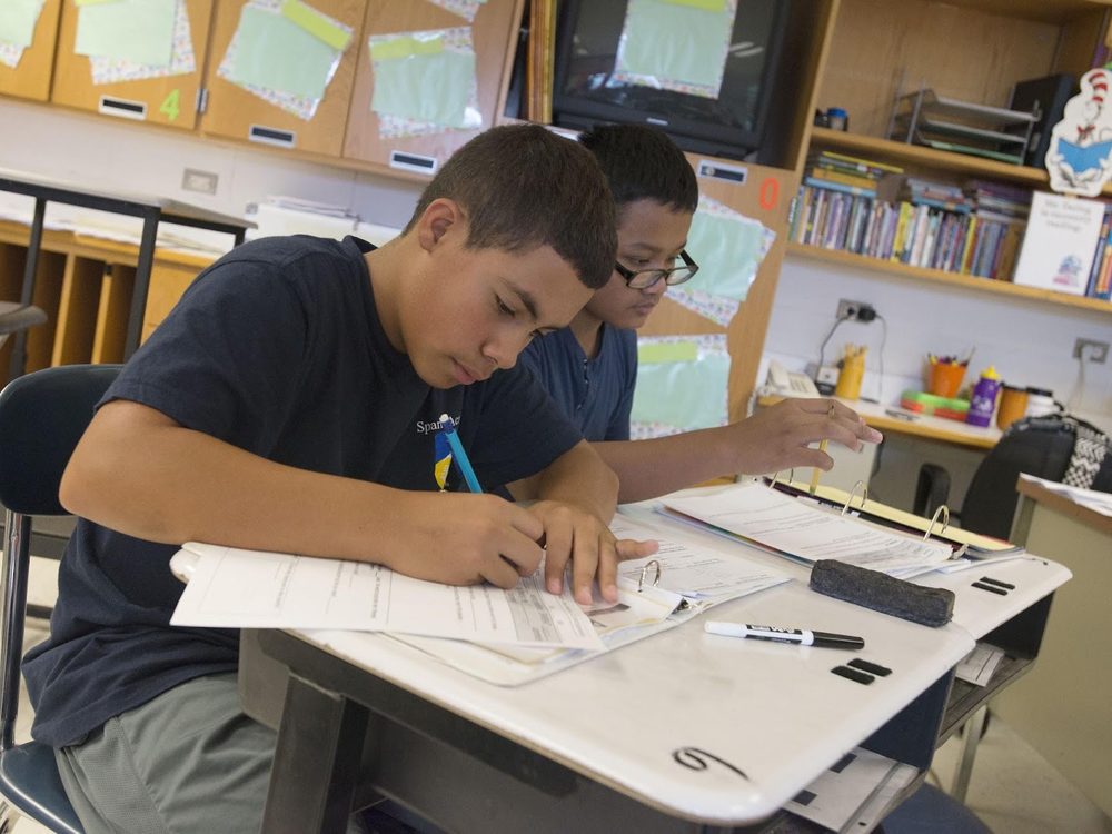 A Spark Academy student working at a standing desk